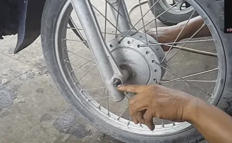 Cẩn thận tháo bu lông trục bánh xe bằng cờ lê 17 để tránh làm toét đầu ren khi thay vòng bi xe máy