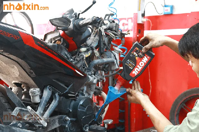 Thợ chuyên nghiệp tiến hành thay dầu nhớt cao cấp Motul 7100 cho xe máy Yamaha tại trung tâm bảo dưỡng
