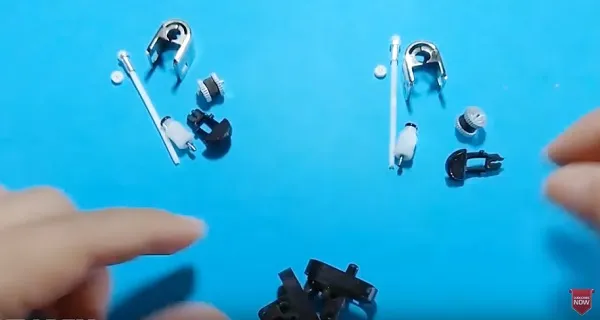 Các bộ phận của bật lửa cũ được tháo rời và sắp xếp, chuẩn bị cho việc chế tạo mô hình xe máy mini.