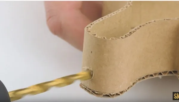 Khoan lỗ trên khung bìa cứng để lắp đèn nháy mini, hoàn thiện chi tiết đầu xe mô hình.