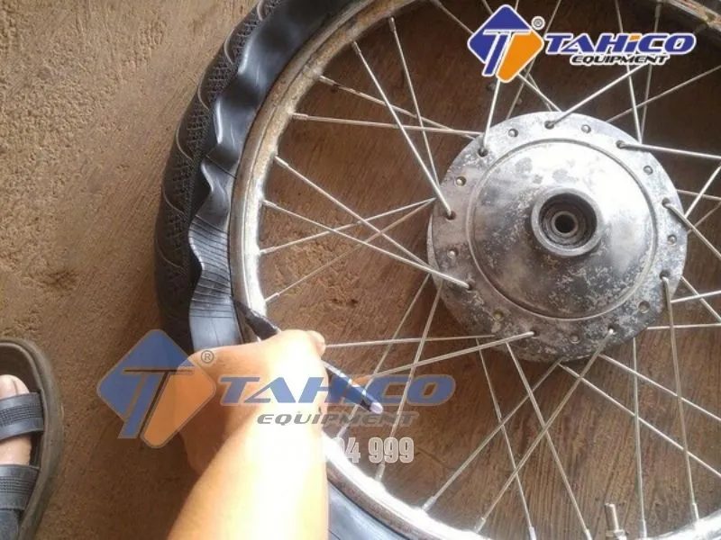 Minh họa kỹ thuật tháo lốp xe máy bằng tay, sử dụng lơ-via để nạy mép lốp tách khỏi vành