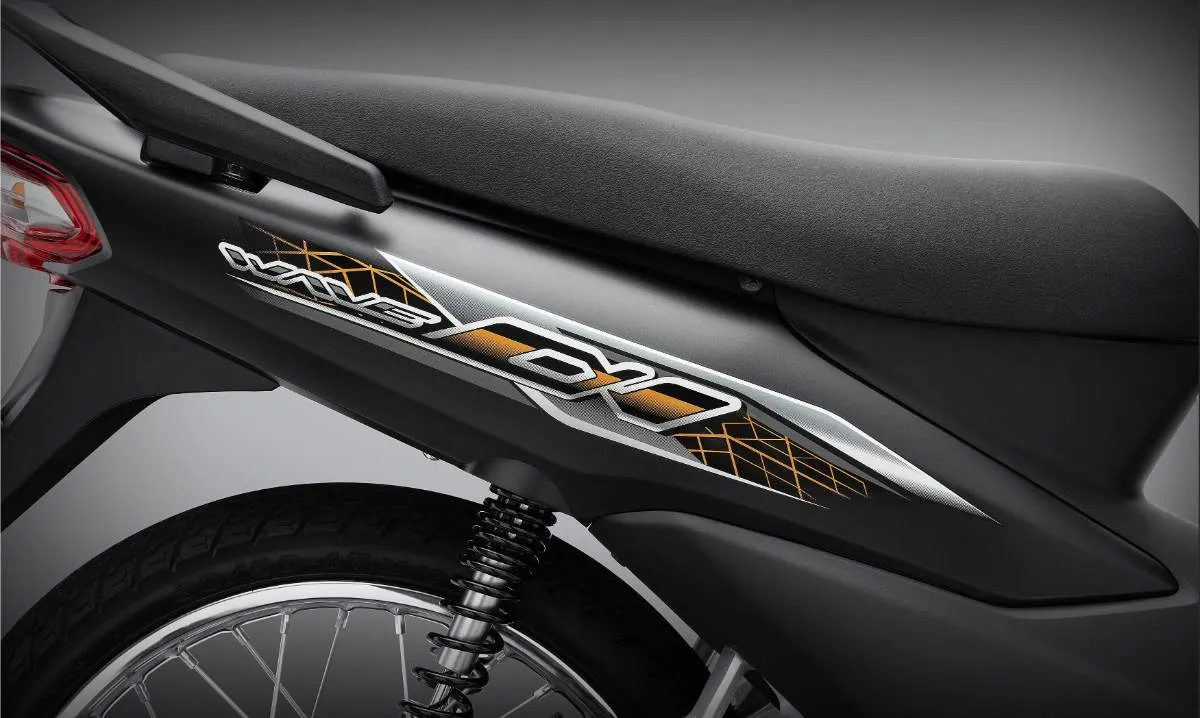 Cận cảnh thân xe Wave Alpha 110 2025, nhấn mạnh logo và tem xe cách điệu trên nền màu sắc tiêu chuẩn