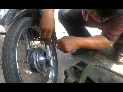 Người thợ đang thực hiện cách khóa càng xe máy và kiểm tra chốt an toàn