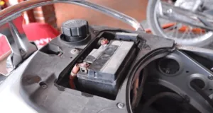 Kiểm tra khu vực hộp ắc quy xe máy để tìm thiết bị theo dõi GPS có dây.