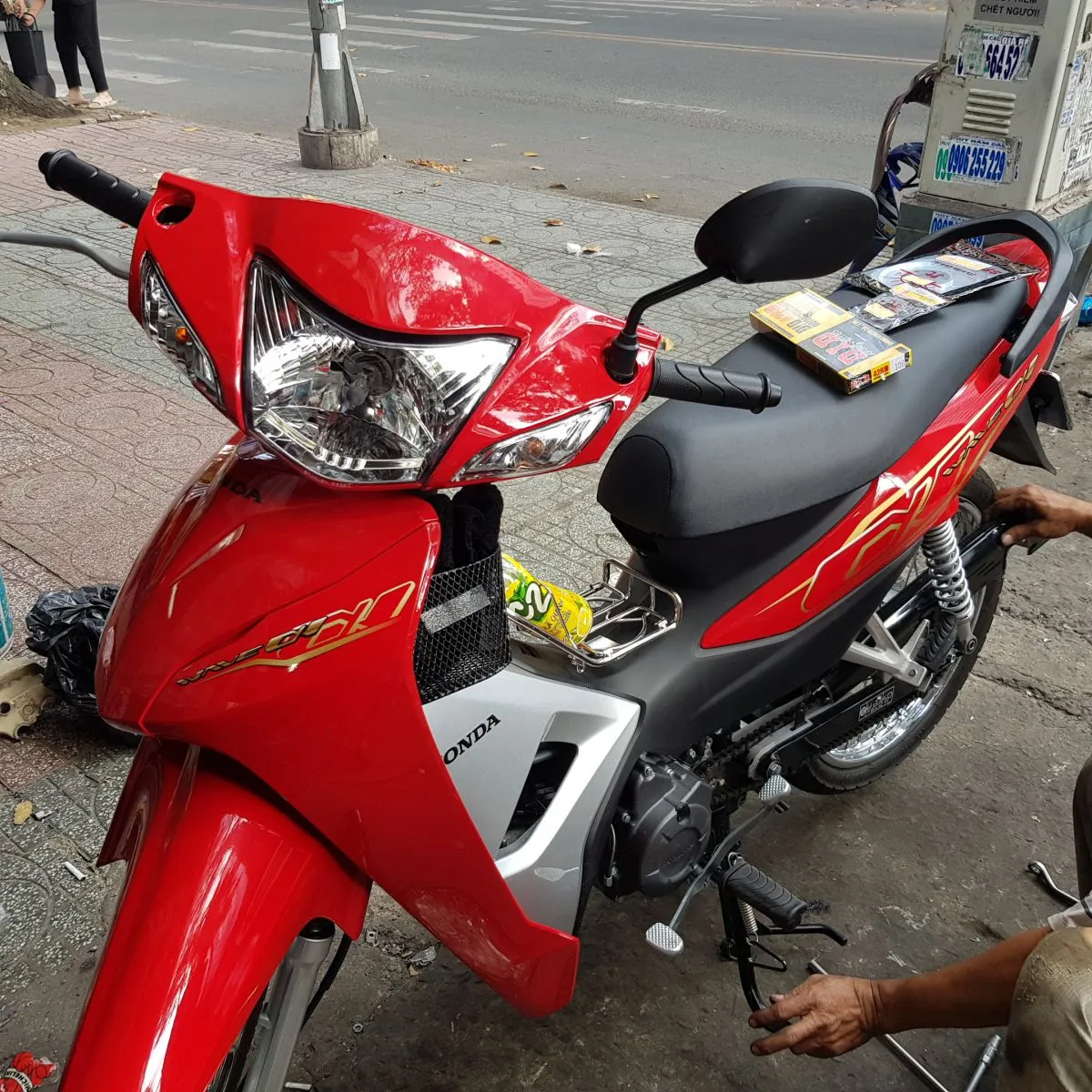 Kỹ thuật viên tháo bỏ bộ nhông xích cũ đã mòn trên xe Wave Alpha 2019