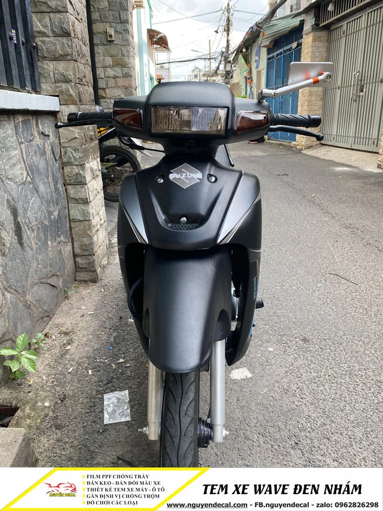 Góc cận cảnh quy trình dán decal đen nhám xe Wave, minh họa kỹ thuật ôm cua và cắt tỉa chính xác.