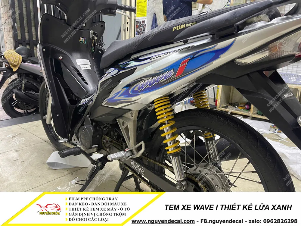 Toàn cảnh chiếc xe Wave i đã được dán tem thiết kế lửa xanh hoàn chỉnh, thể hiện sự chăm sóc kỹ lưỡng và phong cách độ xe độc đáo.