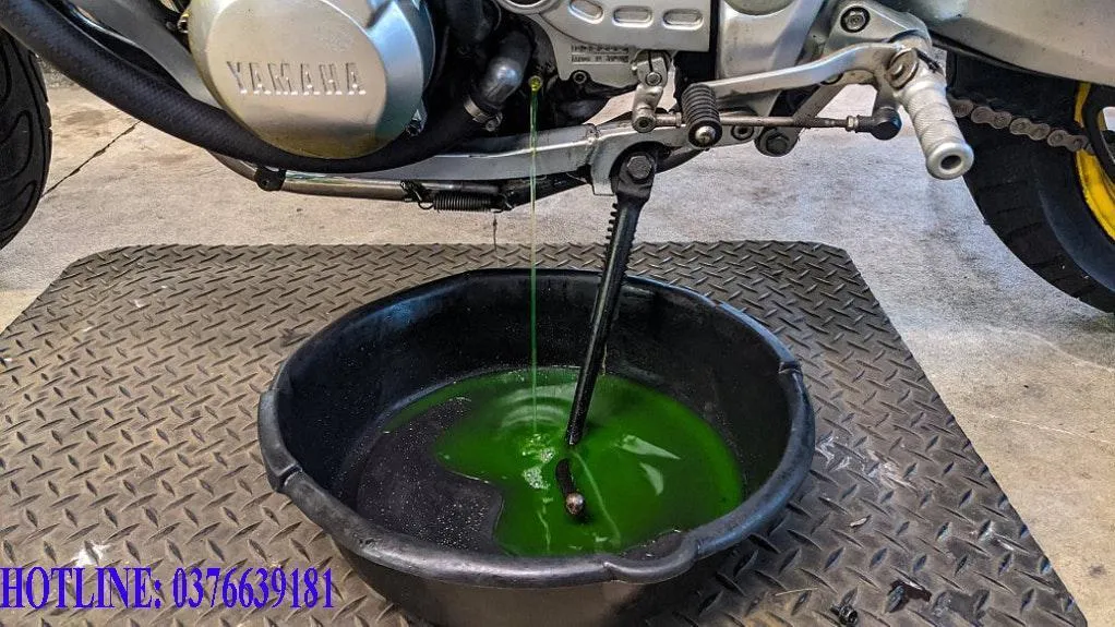 Kỹ thuật viên đang xả nước làm mát cũ từ két nước xe máy