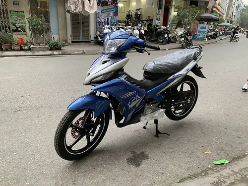 Mô tả hình ảnh: Một chiếc xe máy Exciter 50cc côn tay màu đỏ đen đang dừng.