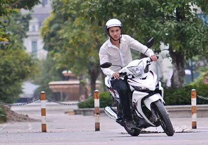 Mô tả hình ảnh một người đang lái xe máy trên đường, nhấn mạnh vào việc kiểm soát tốc độ và tải trọng trong giai đoạn chạy rà xe máy mới