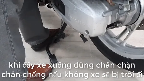 Dùng chân chặn chân chống lại để ngăn xe bị trôi đi