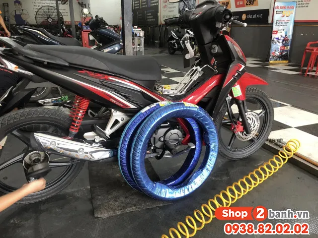 Kỹ thuật viên đang kiểm tra thông số và thay lốp xe Wave Alpha tại cửa hàng