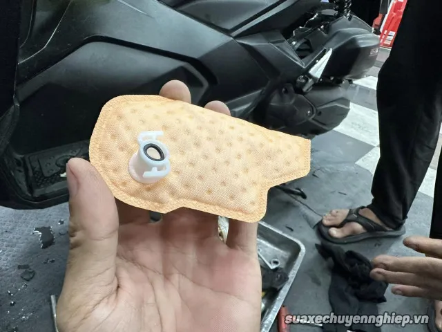 Kỹ thuật viên đang thay thế lọc xăng xe máy tại trung tâm bảo dưỡng