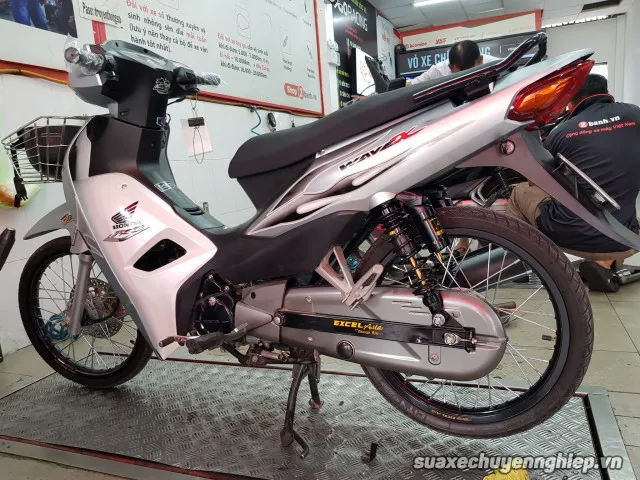 Kỹ thuật viên đang thực hiện bảo dưỡng xe Wave tại trung tâm chuyên nghiệp