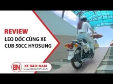 Một chiếc xe Cub 81 50cc màu đỏ đang được một người điều khiển đi lên dốc