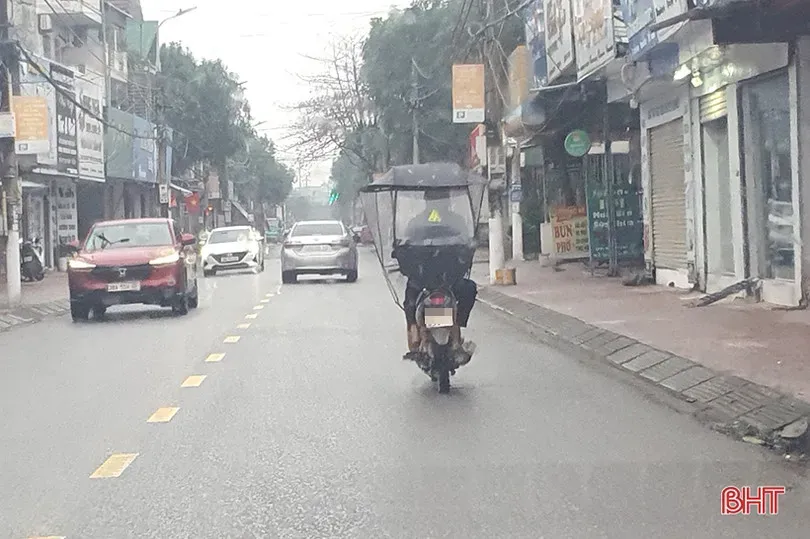 Xe máy với mái che tự chế bị gió cản mạnh, tiềm ẩn nguy cơ quật ngã người và xe trong mưa lớn
