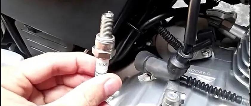 Hình ảnh một kỹ thuật viên đang kiểm tra bugi xe máy Honda