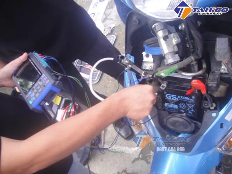 Kỹ thuật viên đang bảo dưỡng ắc quy xe máy