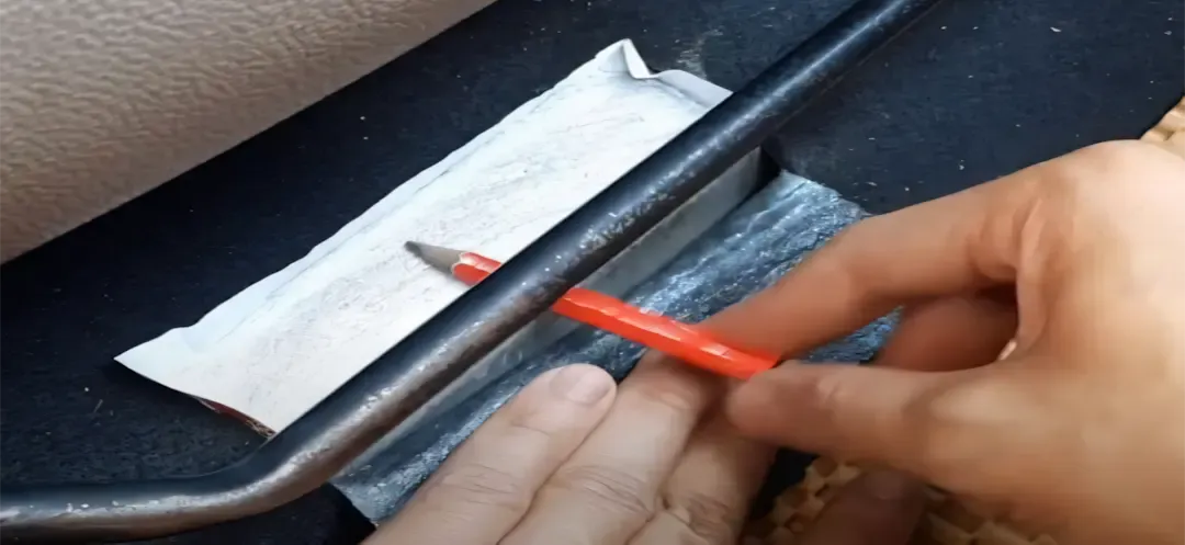 Thao tác bắt đầu quá trình cà số khung xe máy điện VinFast bằng giấy decal và bút chì