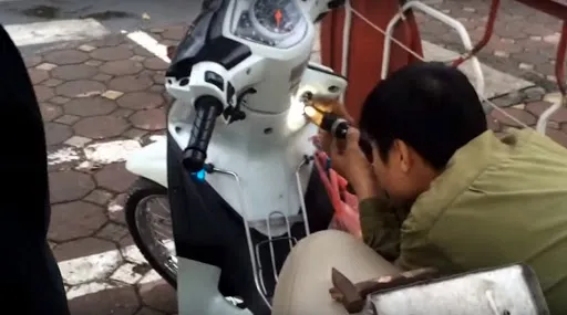 Hình ảnh thao tác mở ổ khóa xe máy bị kẹt bằng chìa khóa và dụng cụ chuyên dụng