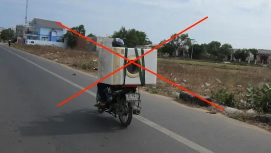 Alt text: Máy giặt được cố định bằng dây chằng chắc chắn trên xe máy để đảm bảo an toàn