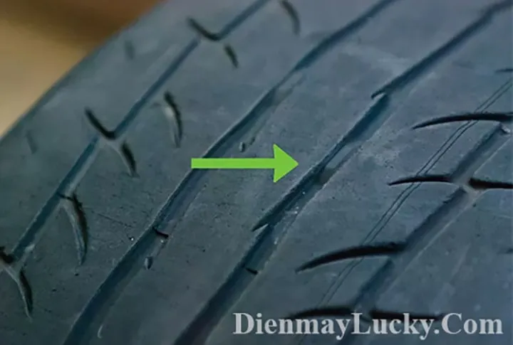 Hình ảnh cận cảnh một chiếc lốp xe máy đang được kiểm tra độ sâu rãnh