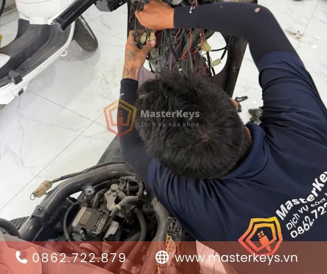 Thợ sửa khóa xe máy chuyên nghiệp đang làm lại chìa khóa xe Dream