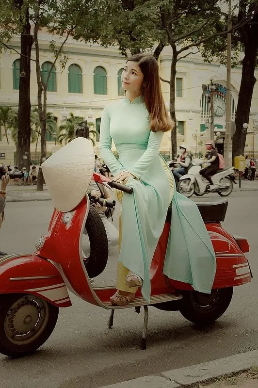 Tạo dáng nhẹ nhàng với xe tay ga, kết hợp áo dài và tà áo tung bay