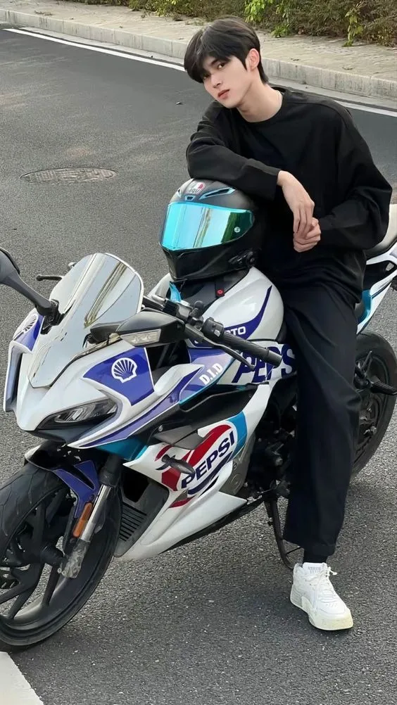 Tạo dáng ngồi trên xe máy, hai chân dạng rộng thể hiện sự phóng khoáng