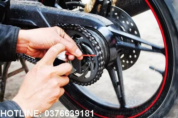 Quy trình thợ sửa xe máy đang thực hiện căng xích xe máy