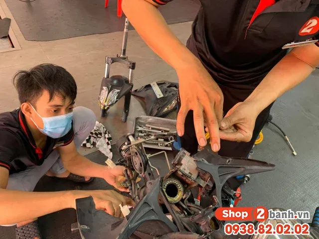 Hình ảnh cận cảnh kỹ thuật viên đang tháo lắp chén cổ trên một chiếc xe máy Honda